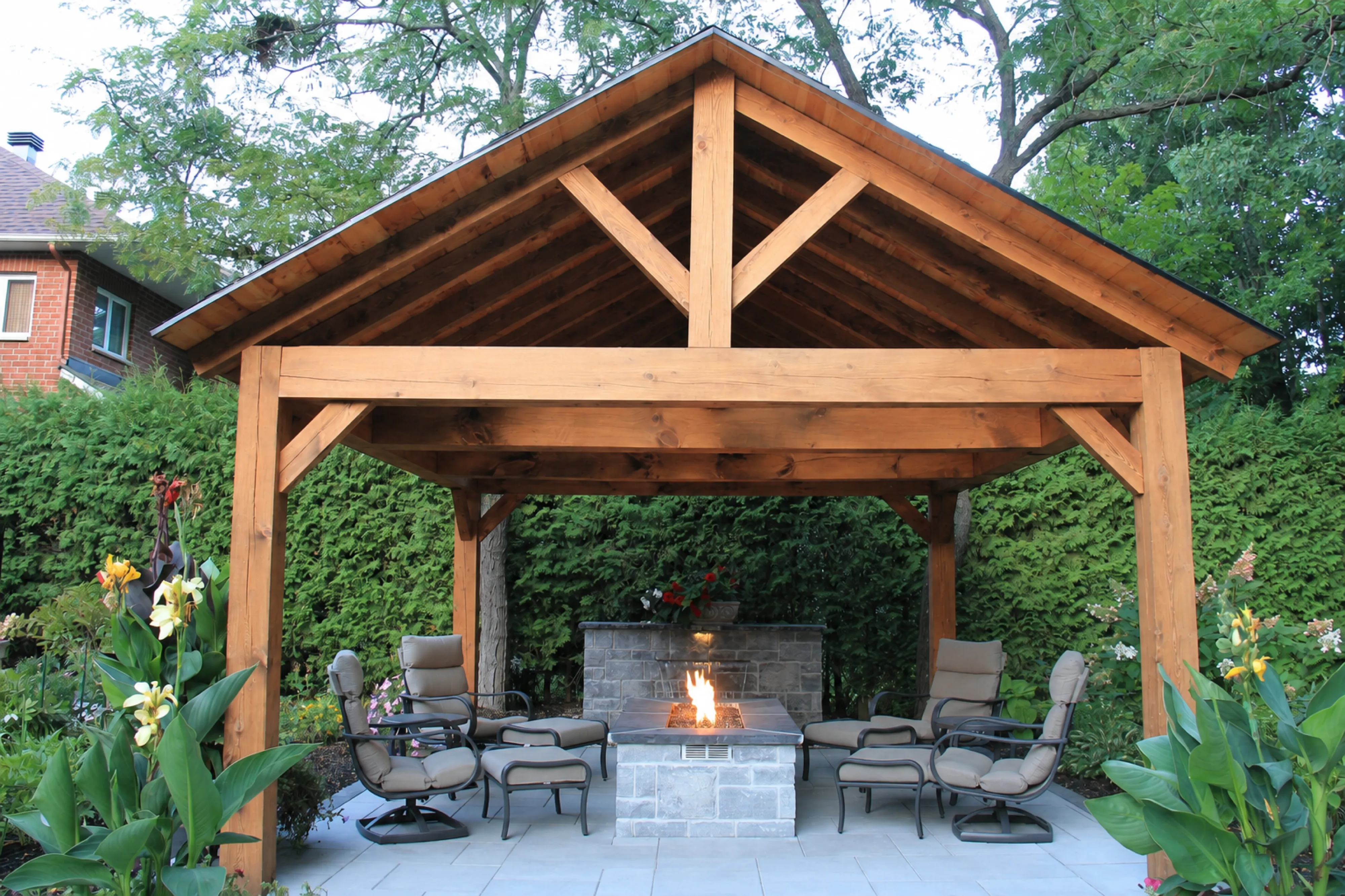 Rivercrest timber pavilion and stone fire feature framed by mature trees