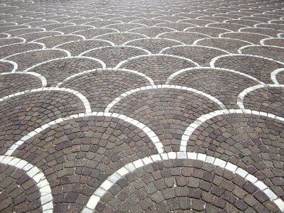 close up of a driveway designed with interlocking bricks and stone in scallop pattern